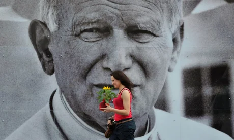 A Polish woman walks past a poster of the late Pope John Paul II in Krakow before his beatification ceremony in 2011.